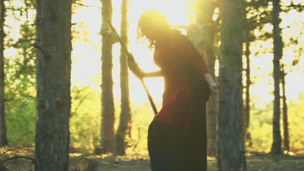sorcière aux cheveux roux marchant dans la forêt 