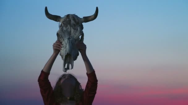 Jonge vrouw verkleed als een heks verhogen van een stier schedel over het hoofd — Stockvideo