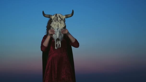 Jonge vrouw verkleed als een heks houden een stier schedel — Stockvideo