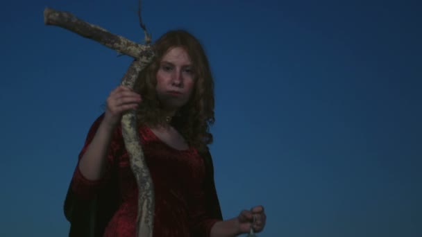 Молодая женщина одета как ведьма позирует с палкой и лампой — стоковое видео