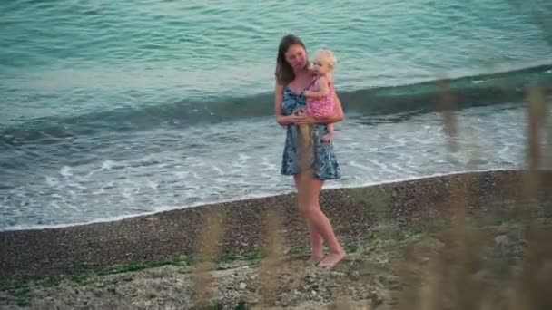 Matka trzyma dziecko dziewczyna spaceru na plaży — Wideo stockowe