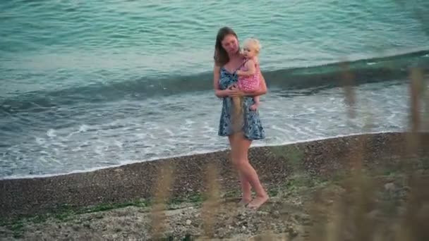 Moeder houden babymeisje wandelen op het strand — Stockvideo