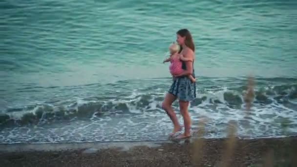 Moeder houden babymeisje wandelen op het strand — Stockvideo