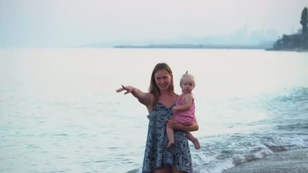 Mother playing with a baby girl on the beach — Stock Video