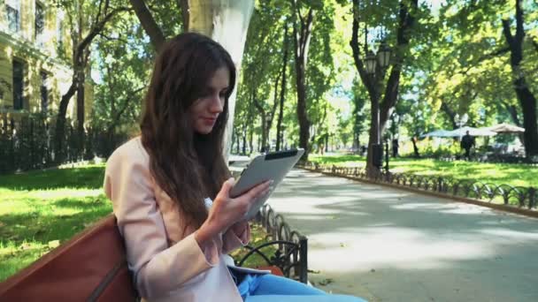 Студентка с планшетом в парке — стоковое видео