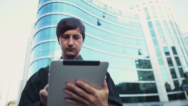 Schöner Geschäftsmann mit einem Tablet auf der Straße Zeitlupe — Stockvideo