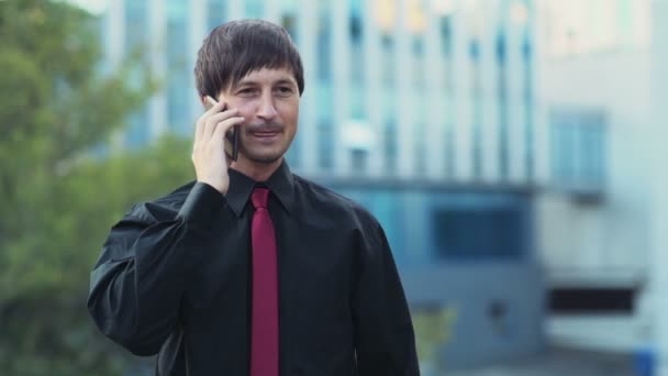 Knappe zakenman praten over de telefoon op de straat slow motion — Stockvideo