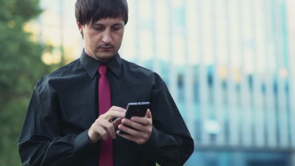 Empresário bonito usando um smartphone na rua câmera lenta — Vídeo de Stock