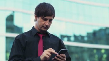 yakışıklı işadamı sokak ağır çekim bir smartphone kullanarak