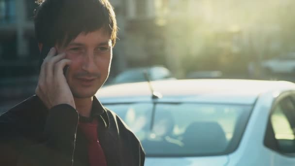 Lächelnder Mann in Hemd und Krawatte telefoniert in Zeitlupe auf der Straße — Stockvideo