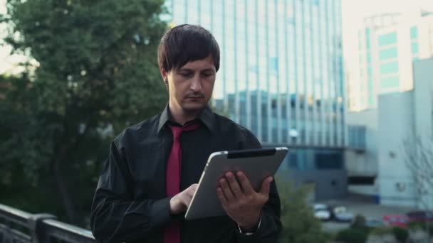 Empresário bonito usando um tablet na rua câmera lenta — Vídeo de Stock