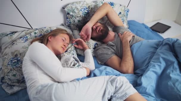 Мужчина и женщина спят в постели — стоковое видео