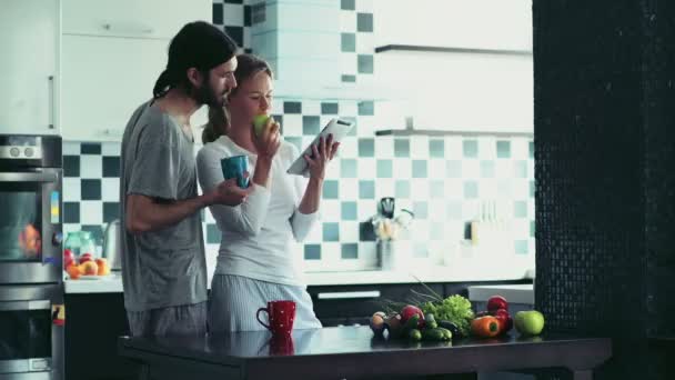 Hombre y mujer usando la tableta en casa durante el desayuno — Vídeo de stock