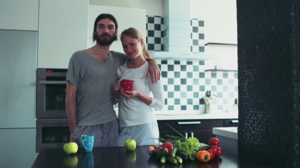 Joven feliz pareja de pie en la cocina en la mañana — Vídeo de stock