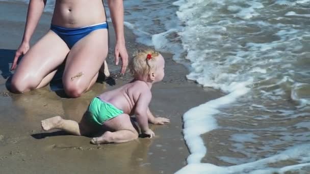 Niño pequeño arrastrándose hacia el mar olas cámara lenta — Vídeos de Stock