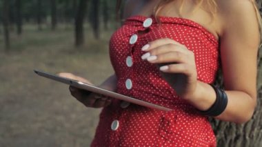 genç kadın bir tablet pc orman yavaş çekimde yüzü kullanır.
