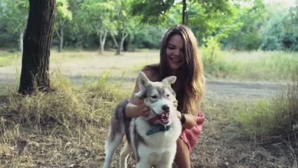 Adolescente joga com um filhote de cachorro descascado na floresta câmera lenta — Vídeo de Stock
