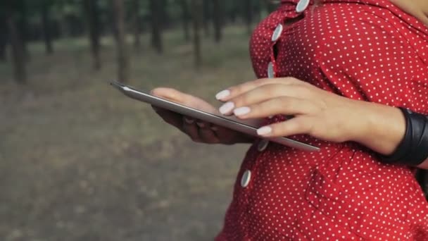 Mujer joven utiliza una tableta de PC en el bosque de cámara lenta sin rostro — Vídeos de Stock