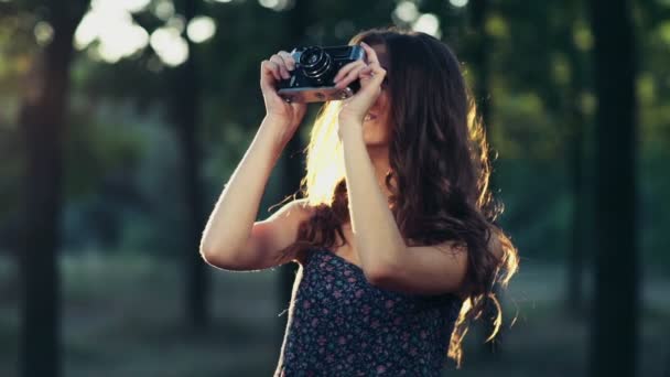 Jeune femme prend des photos avec un vieil appareil photo au ralenti — Video
