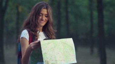 genç kadın, ormandaki bir harita bir kamera yavaş görünüyor