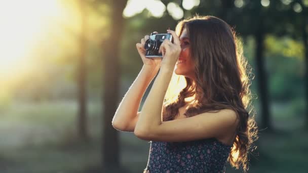 Jovem fêmea tira fotos com uma câmera velha câmera lenta — Vídeo de Stock