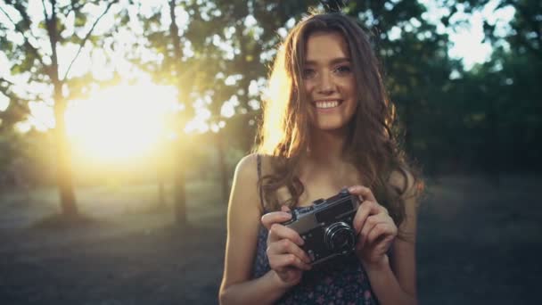 Young female holds an old camera and smiles slow motion — Stock Video