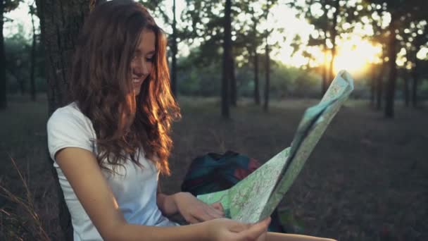 Hembra joven con un mapa en cámara lenta del bosque — Vídeo de stock