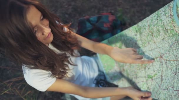 Молодая женщина с картой в замедленной съемке леса — стоковое видео