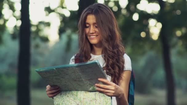 Femmina sorridente con una mappa nel bosco al rallentatore — Video Stock