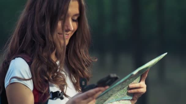 Hembra joven con un mapa y brújula en el bosque cámara lenta — Vídeos de Stock