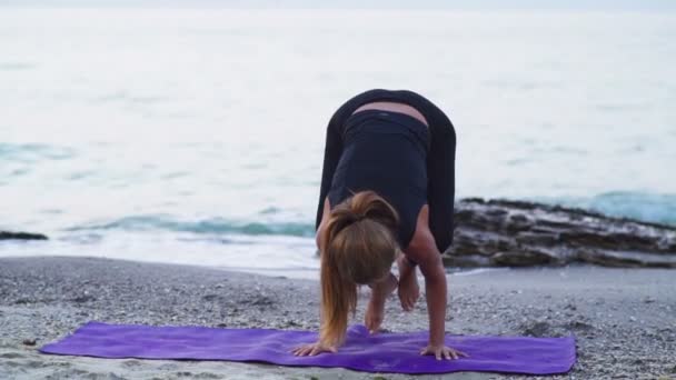 Jovens práticas femininas ioga na praia câmera lenta — Vídeo de Stock