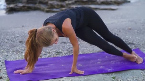 Unga kvinnliga praxis yoga på stranden slow motion — Stockvideo