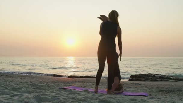 Dos hembras jóvenes practican yoga en la playa cámara lenta — Vídeos de Stock