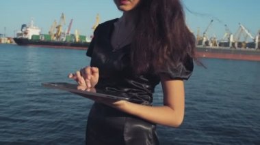 şık iş kadını bir tablet bilgisayar seaport ağır çekimde kullanır.