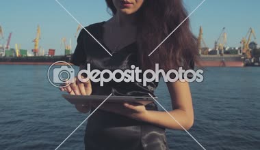 şık iş kadını bir tablet bilgisayar seaport ağır çekimde kullanır.