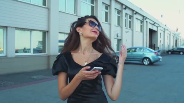 Hermosa bisinesswoman utiliza un teléfono inteligente en el puerto de cámara lenta — Vídeo de stock