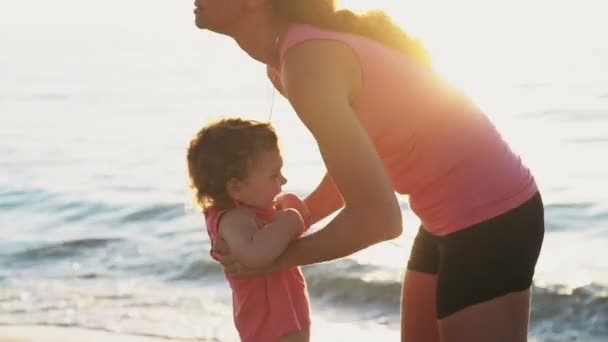 Matka zabiera swojego dziecka na jej ramiona na plaży zwolnionym tempie — Wideo stockowe