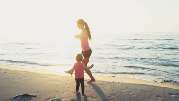 Mor och hennes barn gör gymnastik på stranden slow motion — Stockvideo