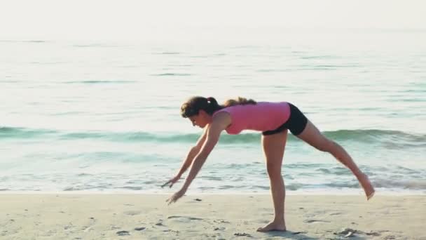 Jeune femme fait de la gymnastique sur la plage au ralenti — Video