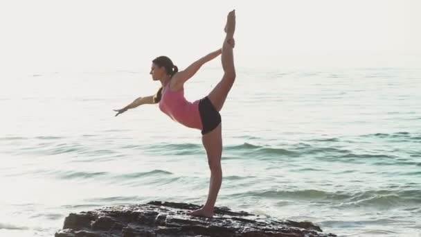 Jonge vrouw doet gymnastiek op het strand slow motion — Stockvideo