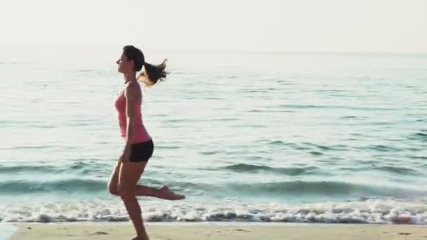 Ung kvinna gör gymnastik på stranden slow motion — Stockvideo