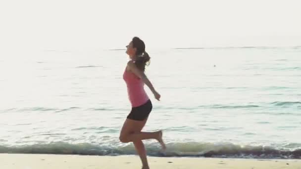 Jonge vrouw doet gymnastiek op het strand slow motion — Stockvideo