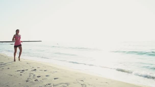 若い女性はビーチのスローモーションでジョギング — ストック動画