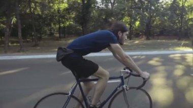 genç yakışıklı adam park yavaş hareket ile bir bisiklet ile gidiyor