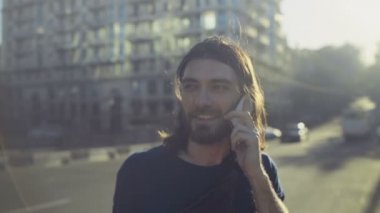 genç adam görüşmeler telefon ve gülümsüyor şehir yavaş hareket