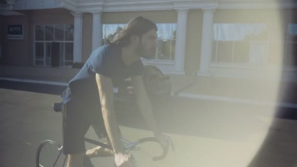 Молодий красивий чоловік їде на велосипеді в парку повільний рух — стокове відео