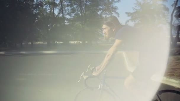 Fiatal jóképű férfi biciklivel megy a park lassítva — Stock videók