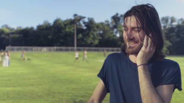 Jeune homme parle au téléphone dans le parc au ralenti — Video