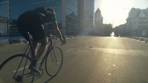 Jovem bonito homem montando uma bicicleta na cidade câmera lenta — Vídeo de Stock