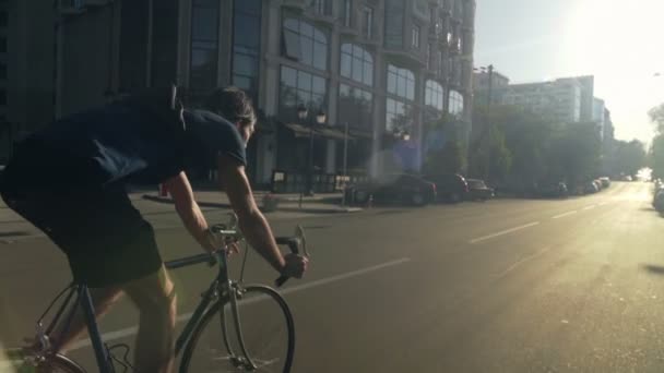 Jovem bonito homem montando uma bicicleta na cidade câmera lenta — Vídeo de Stock